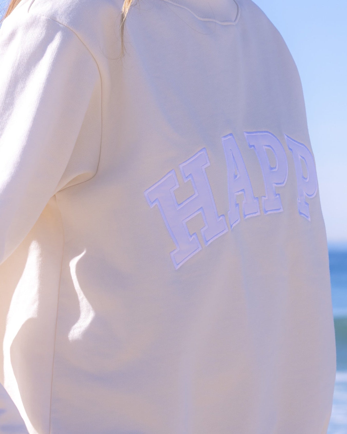 Off white hoodie with white 'HAPPY' text.